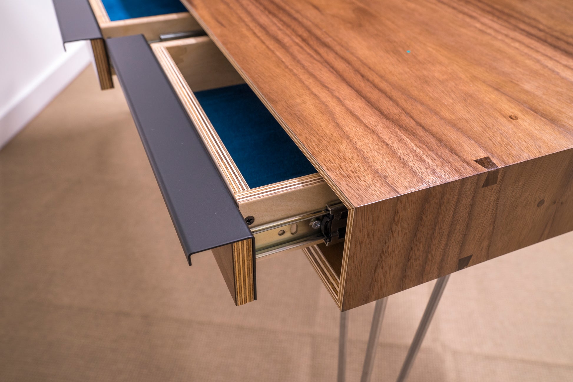 close up of steel drawer hardware and wood details on contemporary walnut desk 